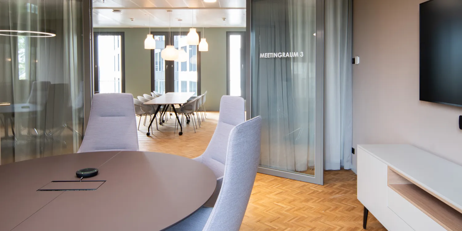 Addleshaw Goddard Frankfurt – Moderner Meetingraum mit Glaswänden, eleganten Möbeln und harmonischer Farbgebung.