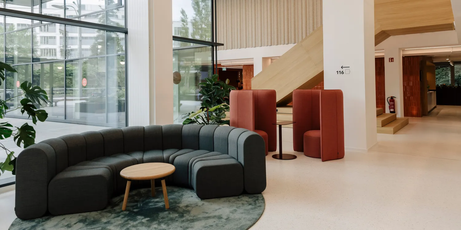 Kustermannpark – Einladende Lobby mit organischen Formen, warmen Materialien und großzügigem Lichteinfall.