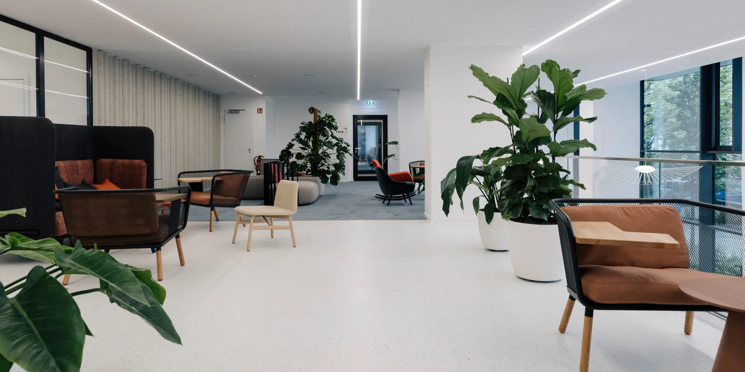 Kustermannpark – Helle Lounge mit modernem Mobiliar, großzügigem Raumgefühl und grünen Akzenten.
