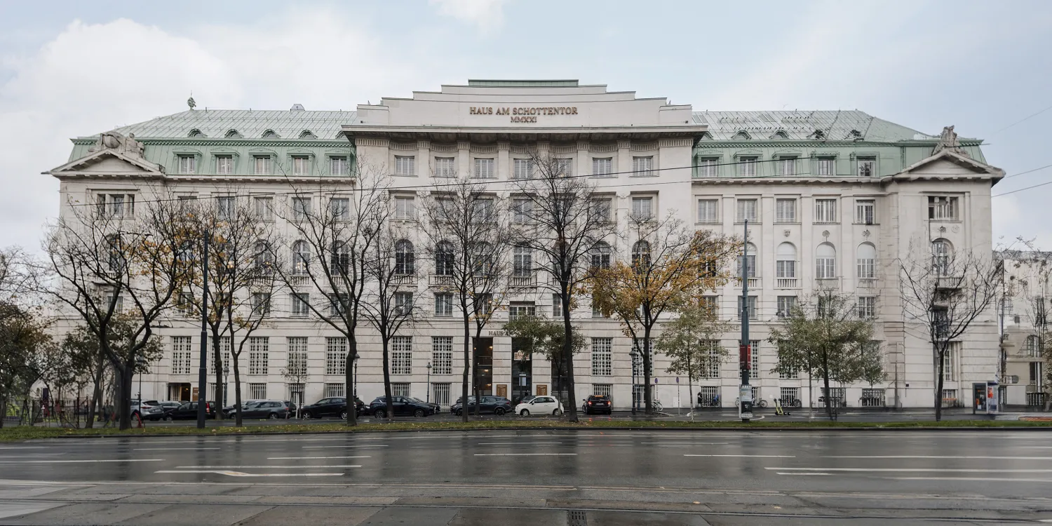 DLA Piper Wien: Prächtige historische Fassade mit Säulen, symmetrischer Architektur und begrüntem Vorplatz