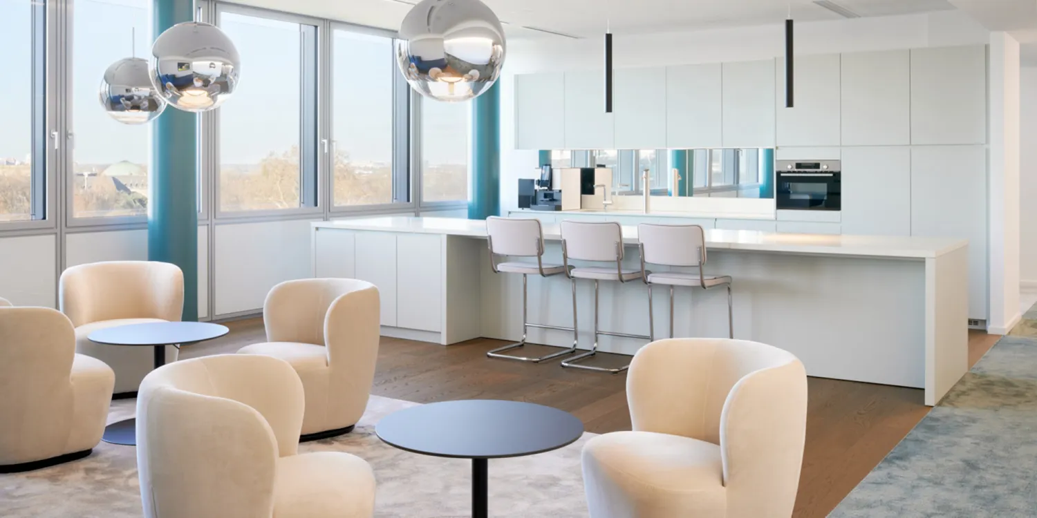 Hogan Lovells – Moderne Büro-Lounge mit Designküche, gemütlichen Sitzbereichen und hochwertigem Interior Design.