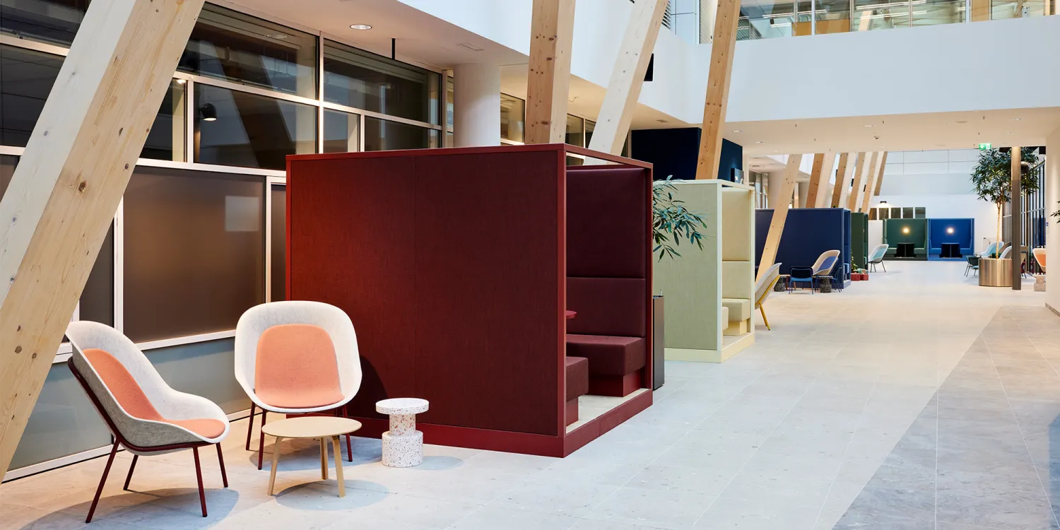 Bosch: Eine offene Bürolandschaft mit Holzstützen, farbigen Sitznischen, Lounge-Sesseln und modernen Beleuchtungen.