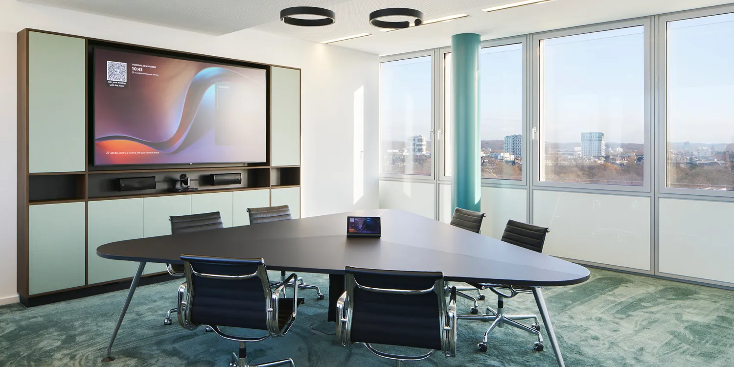 Hogan Lovells: Ein moderner Konferenzraum mit großem Bildschirm, trapezförmigem Tisch, Lederstühlen und Panoramablick.