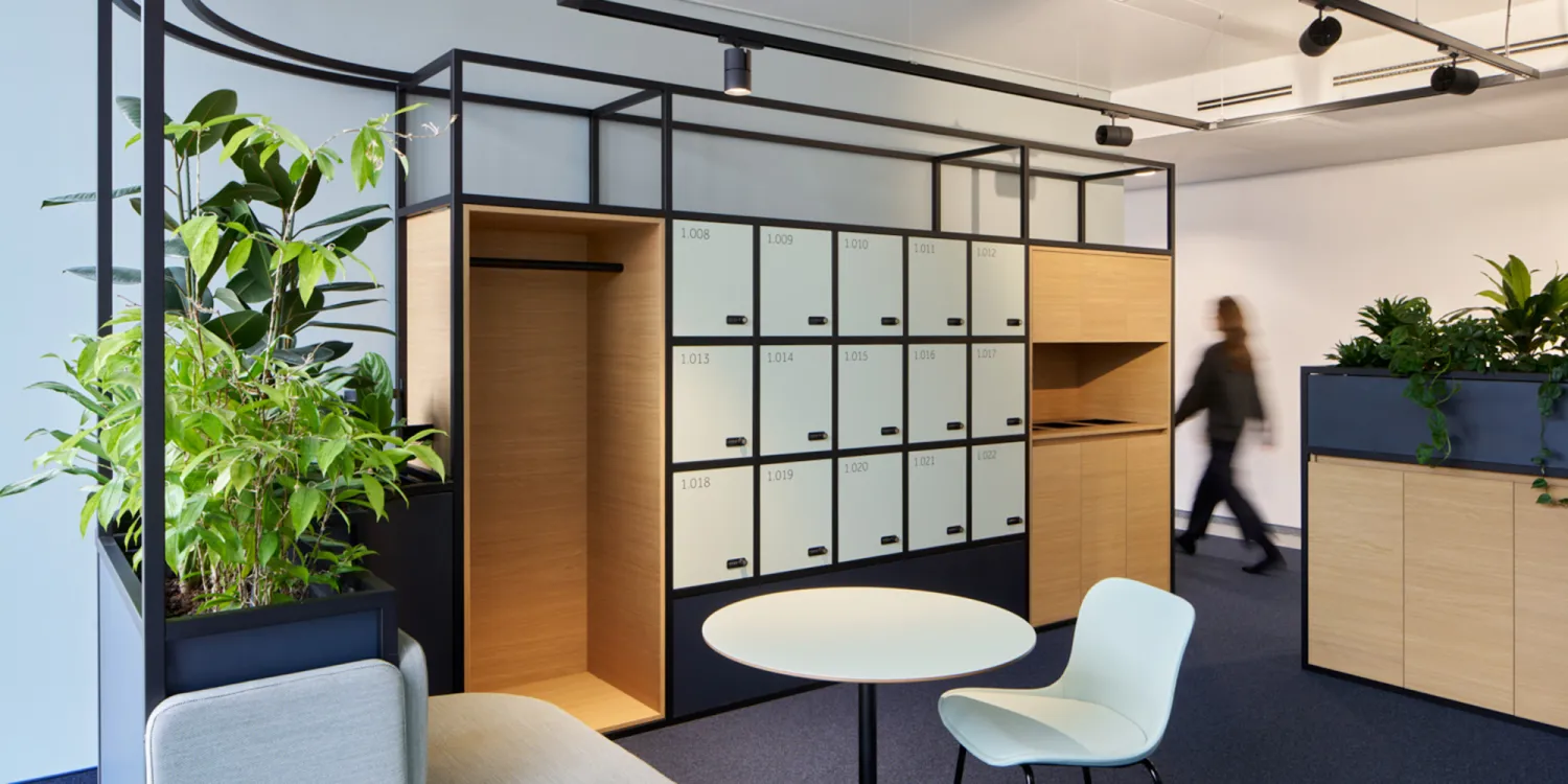 DLL Düsseldorf: New Work: DLL Düsseldorf – Besprechungsecke mit Pflanzen, runder Tisch und Sichtschutz in japanischer Ästhetik.