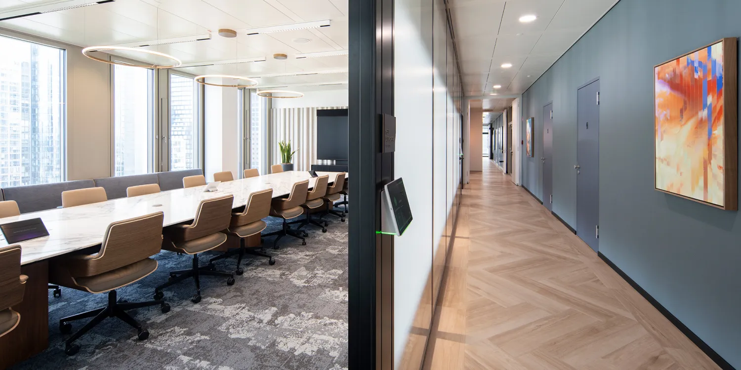 Investment Bank Firm: Moderner Besprechungsraum mit langem Tisch. Blick in den Büroflur mit Fischrätparkett am Boden und warme Wandgestaltung