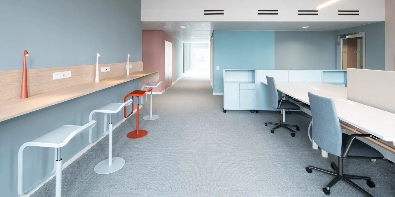 Maxon Follow – Schwebende Holztheke mit Designhockern und integrierter Stromversorgung.