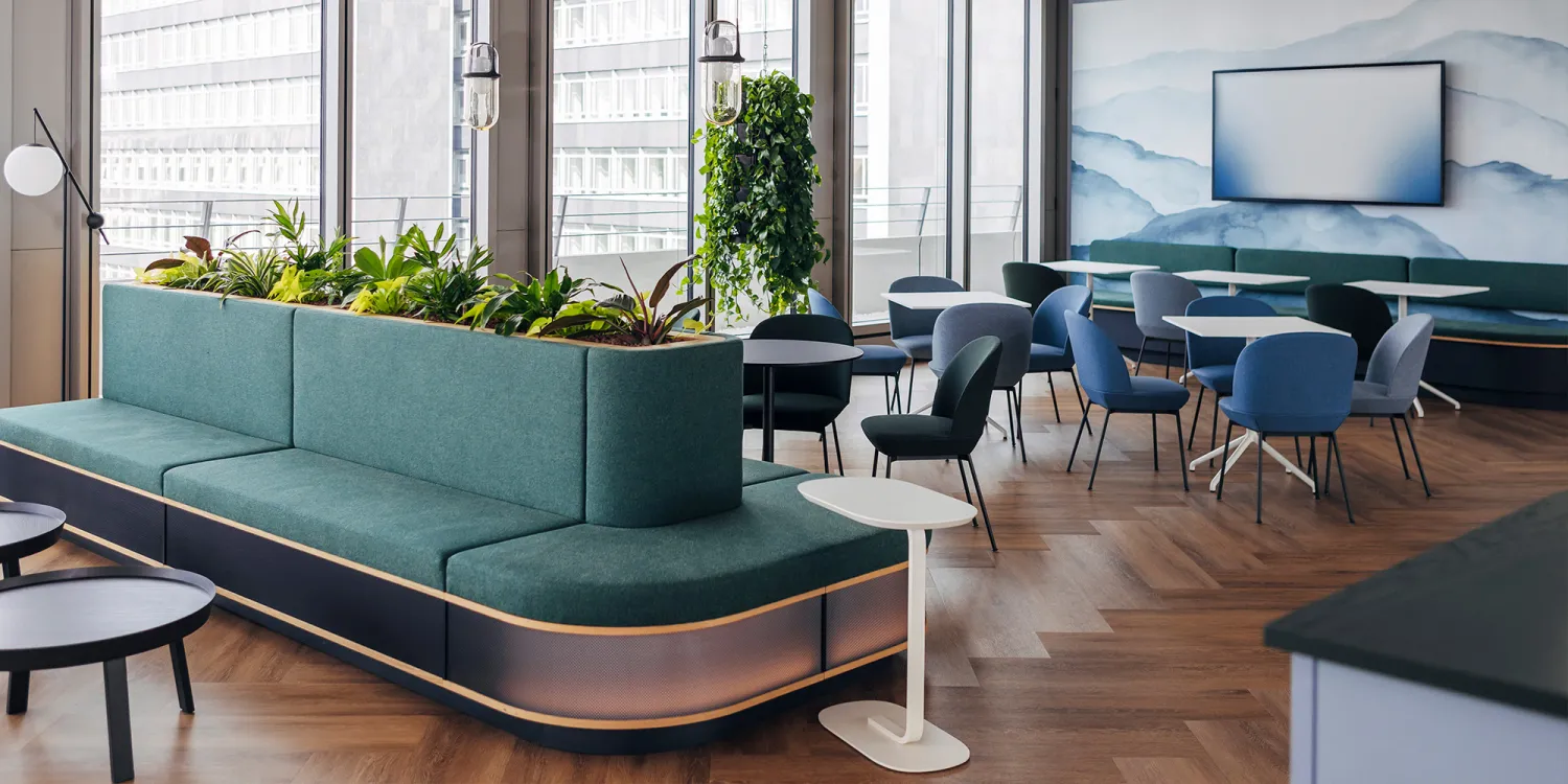 Air Liquide – Offene Lounge mit grünen Sitzinseln, Pflanzen und modernen Café-Bereichen