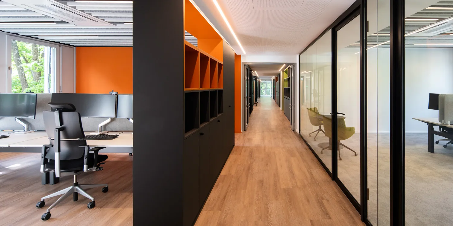 Energieunternehmen – Moderner Büroflur mit Glasräumen und flexiblen Trennwänden.