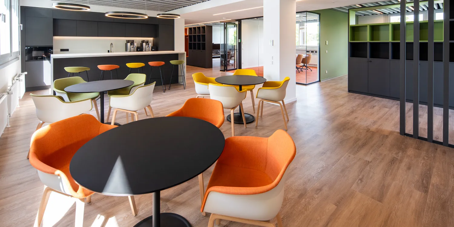 Energieunternehmen: Moderne Lounge mit bunten Stühlen und offener Kaffeebar.