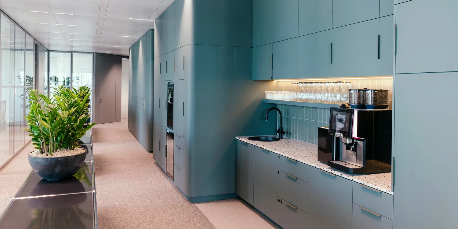 Wirtschaftskanzlei: moderne petrol farbige Küchenzeile mit viel Staufläche.