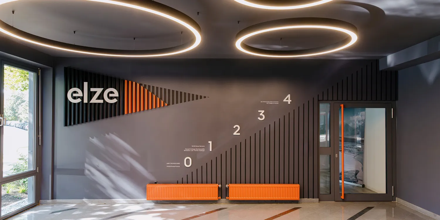 Elsenheimerstraße – Eingangsbereich mit runden Leuchten und orangen Sitzbänken.