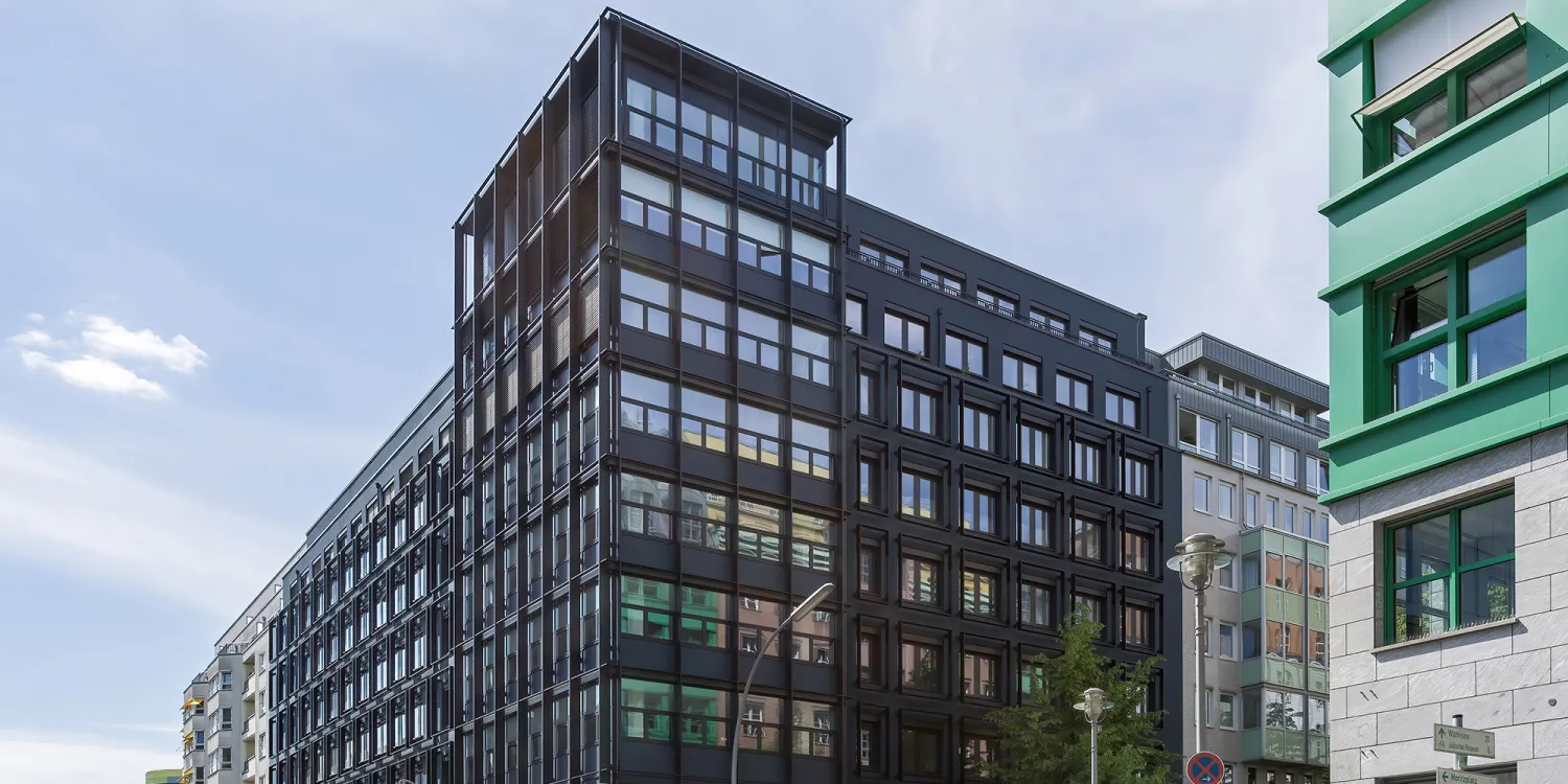 Markgrafenstrasse 62 in Berlin: Gebäude von Aussen mit viel Galsfront und einer dunklen Fassade