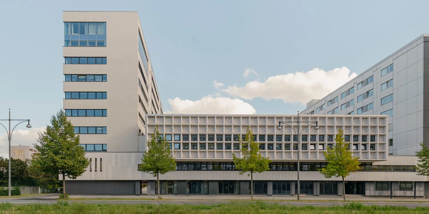 Mollstraße 1, Berlin – Seitenansicht eines Hochhauses mit Flachdach Anbau.
