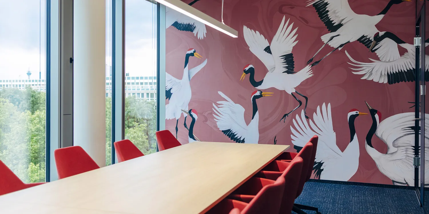 CSMM gestaltet agiles Raumkonzept für Air Liquide: Besprechungsraum mit großen Kranichen auf roter Tapete.