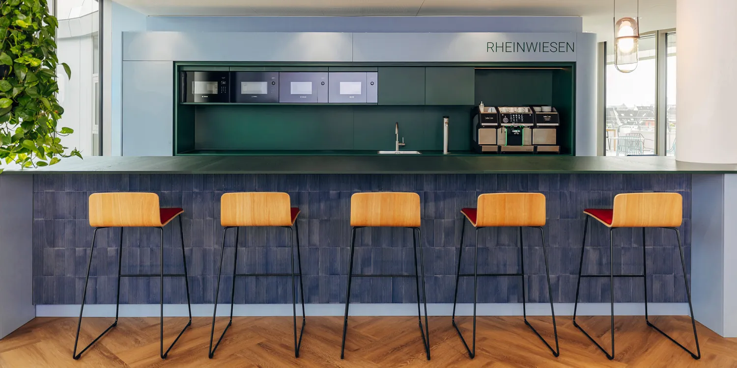 CSMM gestaltet agiles Raumkonzept für Air Liquide: moderne Küchenzeile mit Tresen und Hockern