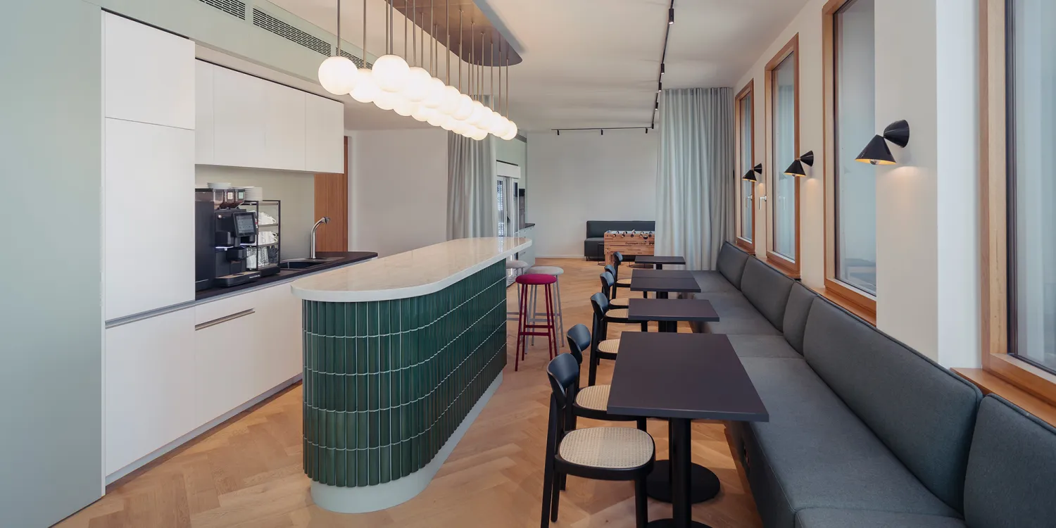 Berliner Linklaters-Office: helle moderne Küche mit großer langer Sitzbank.