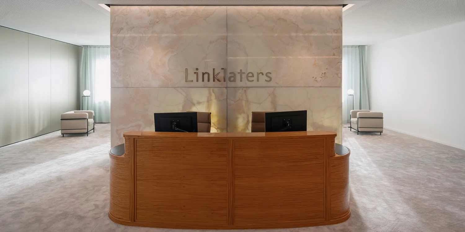 Berliner Linklaters-Office: eleganter moderner Empfangstresen mit Marmorwand im Hintergrund.