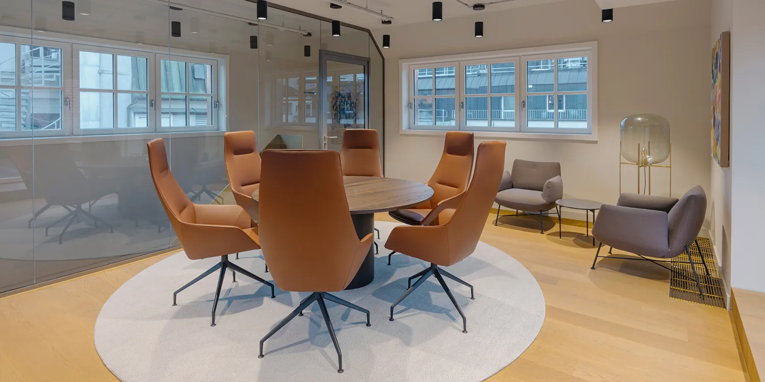 Ashurst München: heller großer Besprechungsraum mit rundem Tisch und 6 Bürostühlen