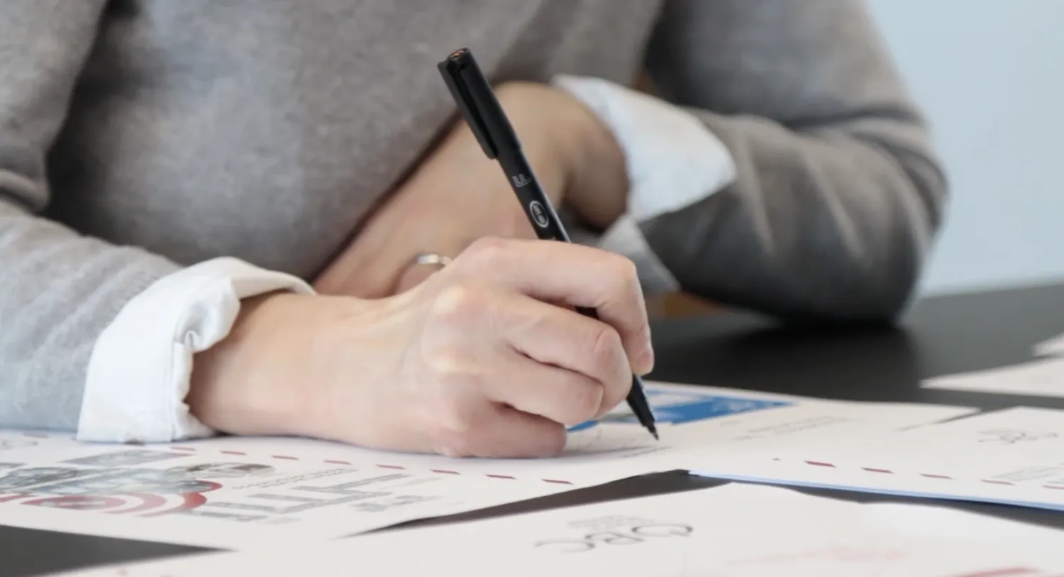 Architektin sitzt am Schreibtisch und macht Notizen.