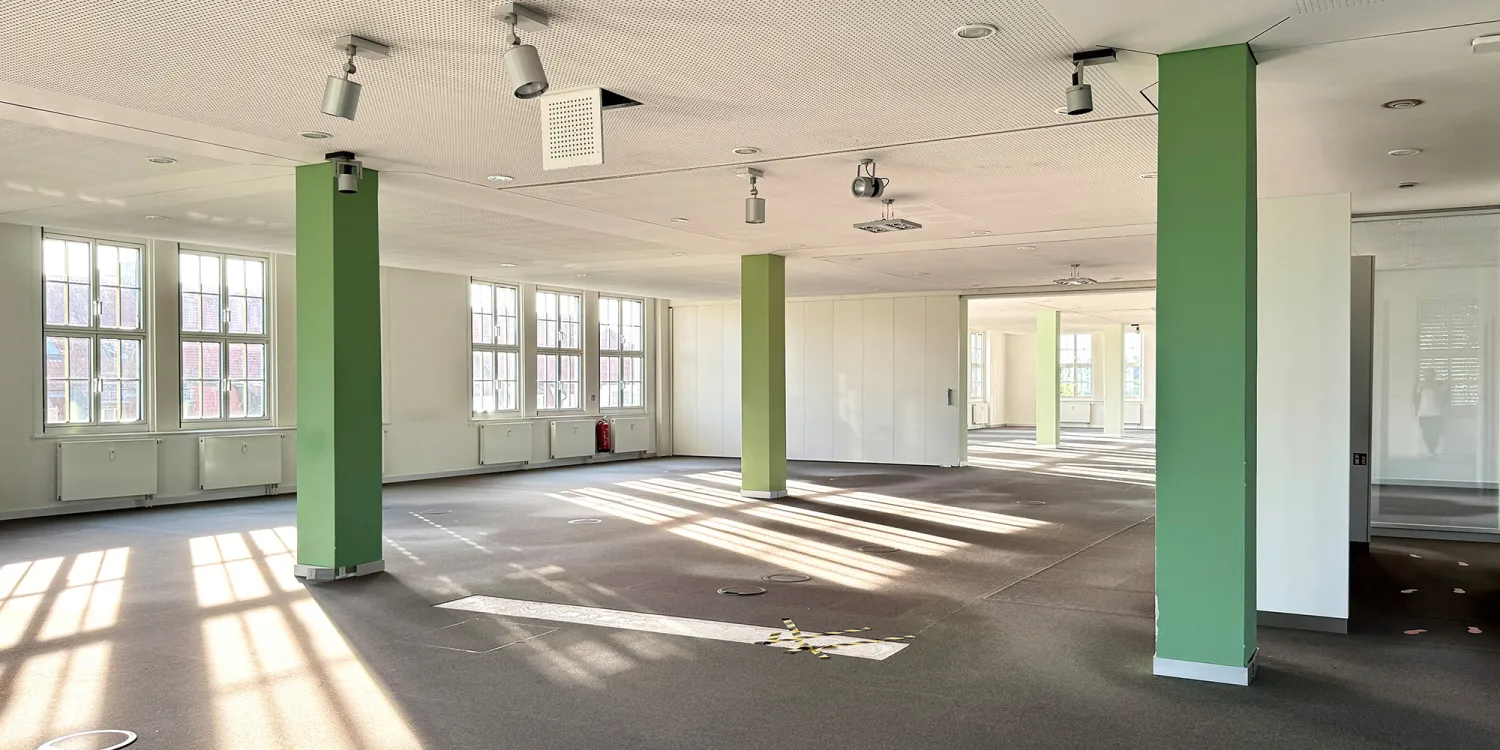 Office Relocation: Großer leerer Raum mit Säulen in grüner Farbe