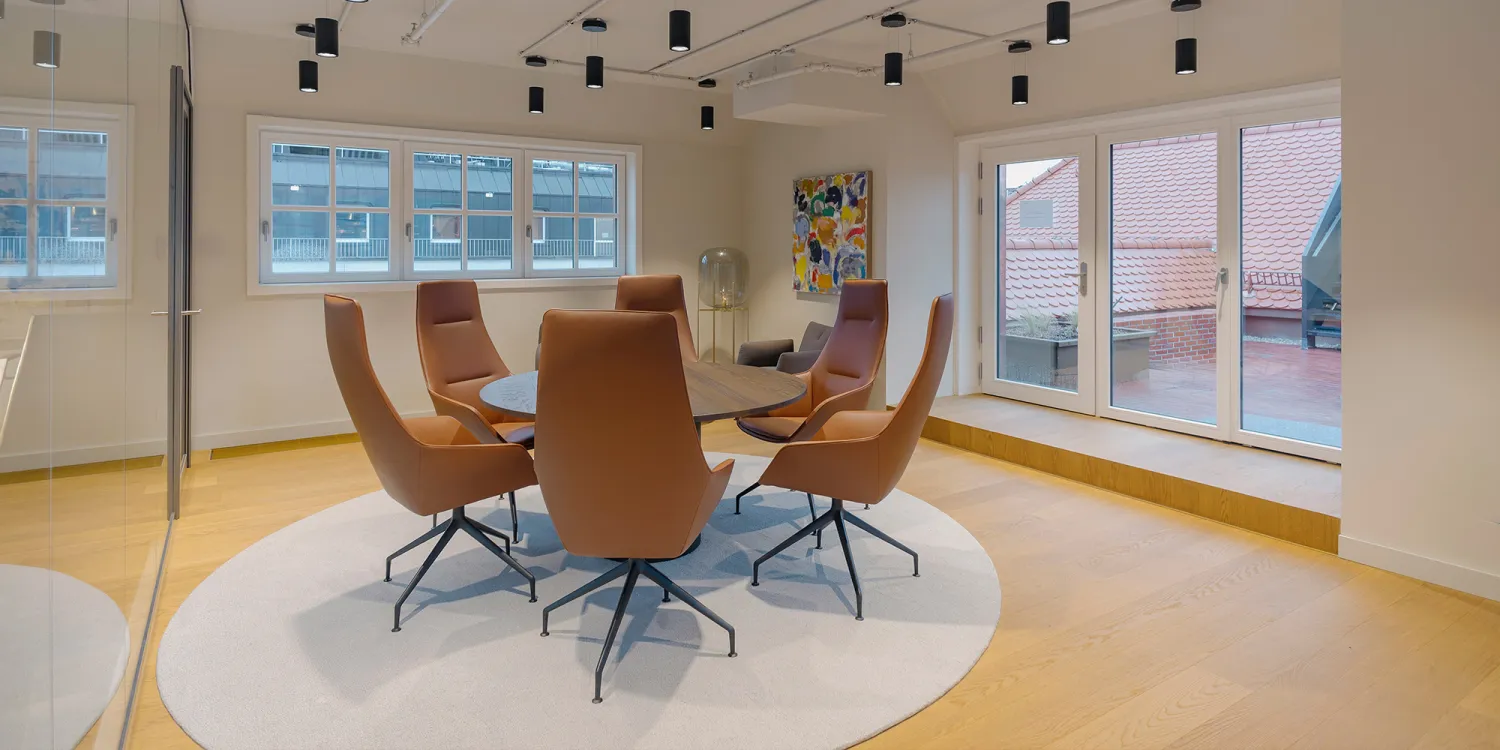 Ashurst München: heller großer Besprechungsraum mit rundem Tisch und 6 Bürostühlen