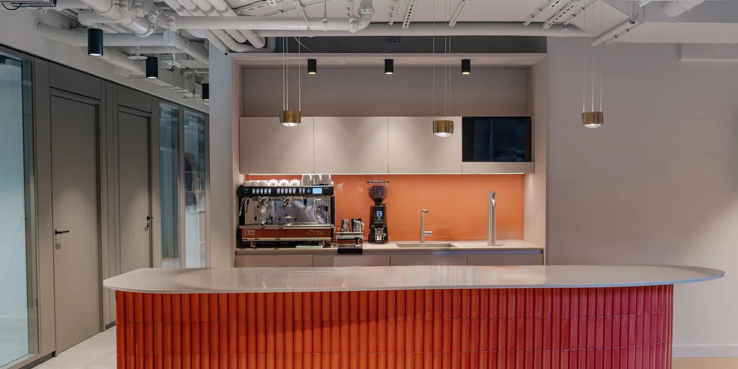 Ashurst München: heller Empfangsbereich mit goldener Theke und loungeartigen Sitznischen.