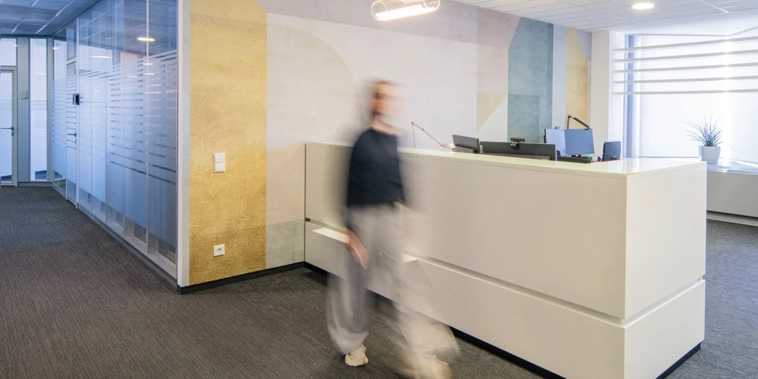 Oliver Wyman: Empfangsbereich mit geometrischer Wandgrafik und moderner Lichtstruktur.