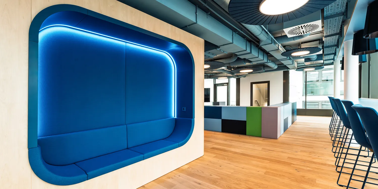 BFV Office4you – Lounge mit blauen Barhockern und offener Technikdecke