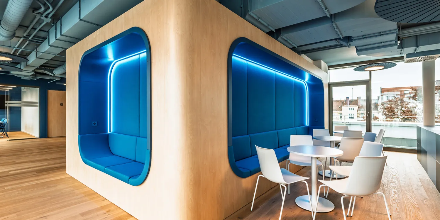 BFV Office4you – Lounge mit blauen Barhockern und offener Technikdecke