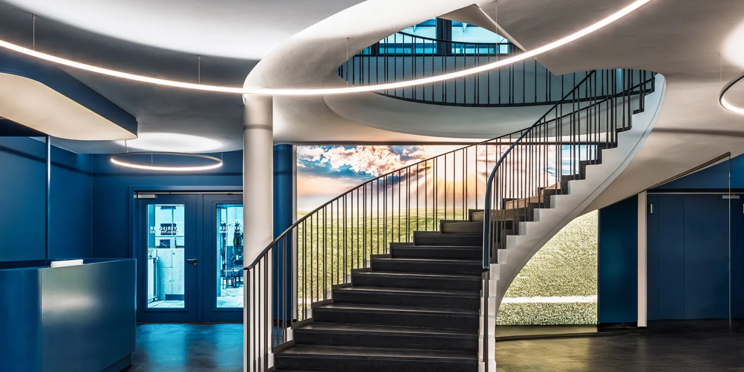 BFV Office4you – Lounge mit blauen Barhockern und offener Technikdecke