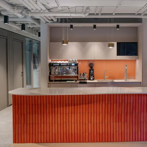 Ashurst München: heller Empfangsbereich mit goldener Theke und loungeartigen Sitznischen.