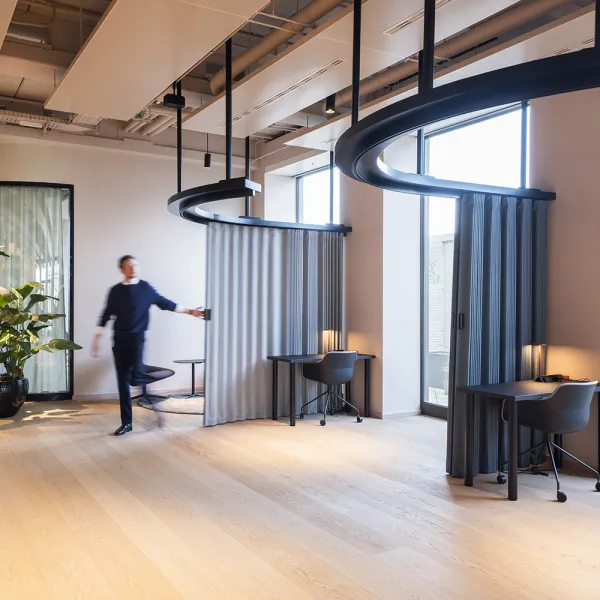 Flexible Arbeitsbereiche mit schwenkbaren Vorhängen, warmem Holzboden und urbanem Blick im Opernturm.