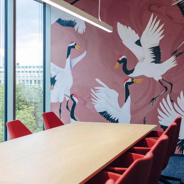 AirLiquide Düsseldorf: Moderner Besprechungsraum mit einem großen Tisch und einer Wand mit Kranichmotiv im Hintergrund