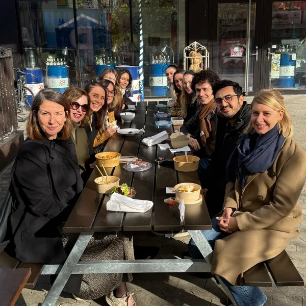 Welcome Days CSMM 2025: Personen sitzen beim Mittagessen um einen großen Tisch im Freien.