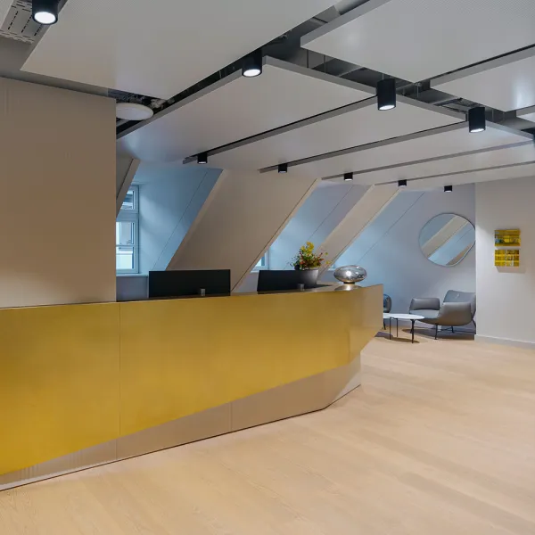 Ashurst München: heller Empfangsbereich mit goldener Theke und loungeartigen Sitznischen.