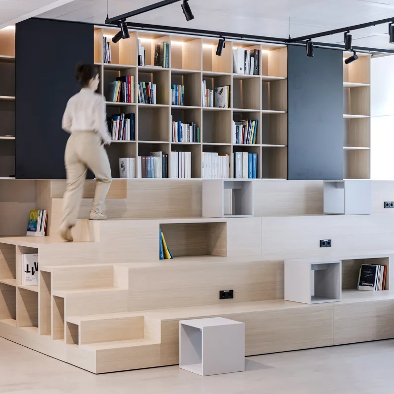BSH – Moderne Bibliothekslandschaft mit skulpturaler Sitztreppe als inspirierender Ort für Austausch und Rückzug.