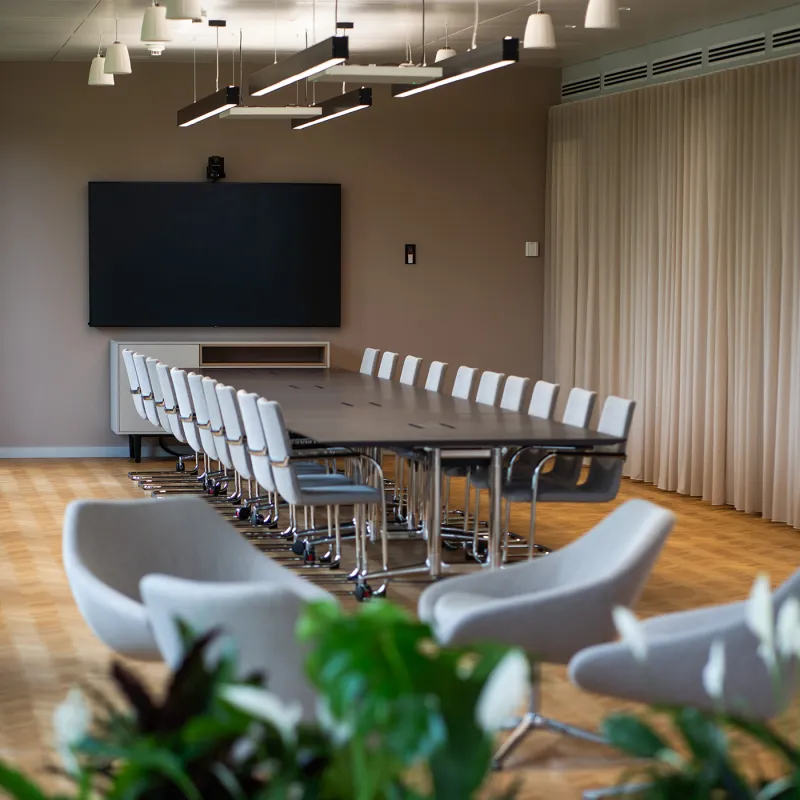 Addleshaw Goddard Frankfurt – Hochwertiger Konferenzraum mit modernem Design, warmen Farben und Pflanzenakzenten.