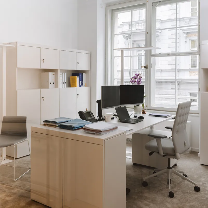 DLA Piper Wien: Helles Büro mit modernem Schreibtisch, ergonomischem Stuhl und großen Fenstern.