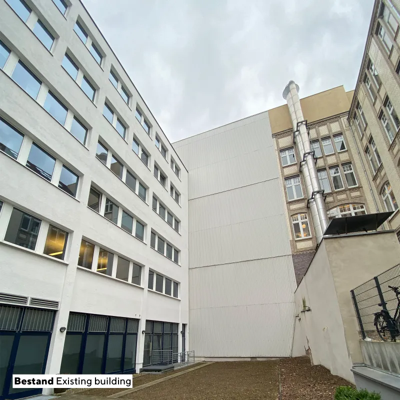 Innenhof des Projekts Quest mit weißer Fassadengestaltung, klaren Linien und urbanem Ausblick.