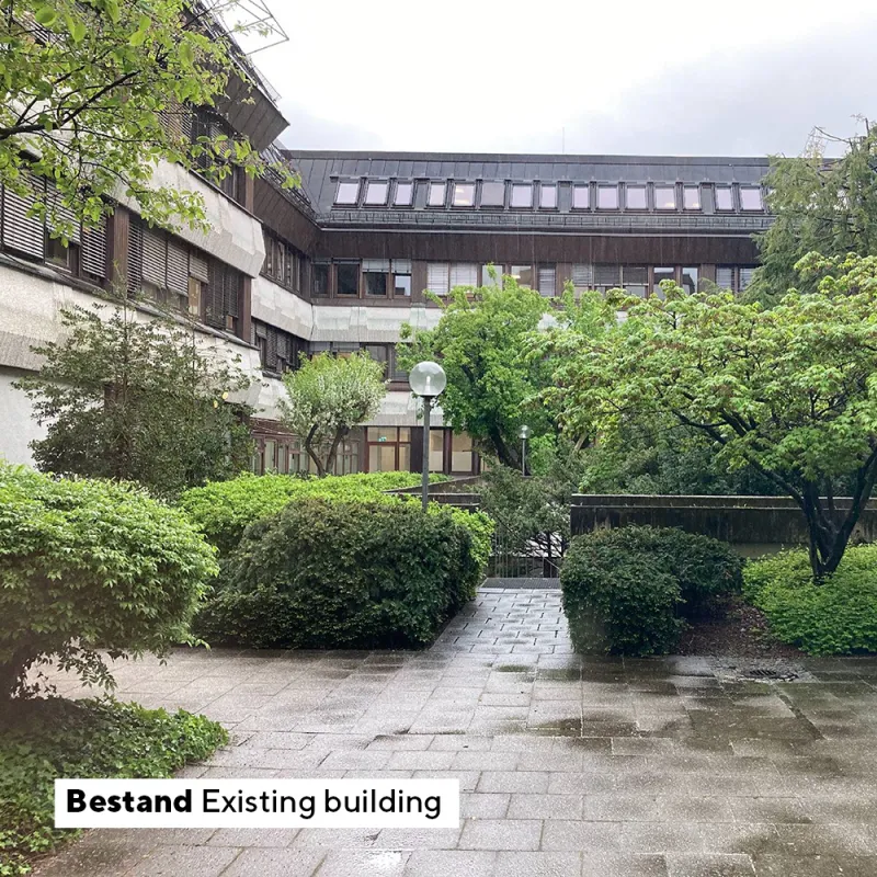 NMKT: Bestand mit dunklem Dach, Betonfassade und dicht bepflanztem Innenhof bei Regen.