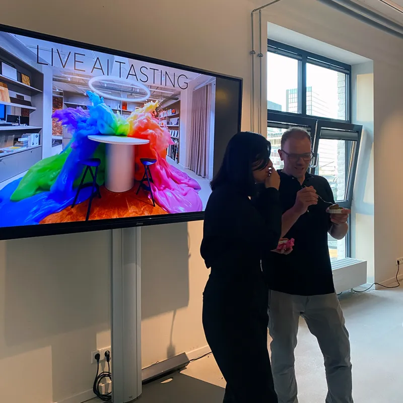 Live AI Tasting in Düsseldorf: Monitor mit einer Animation und davor stehen zwei Personen
