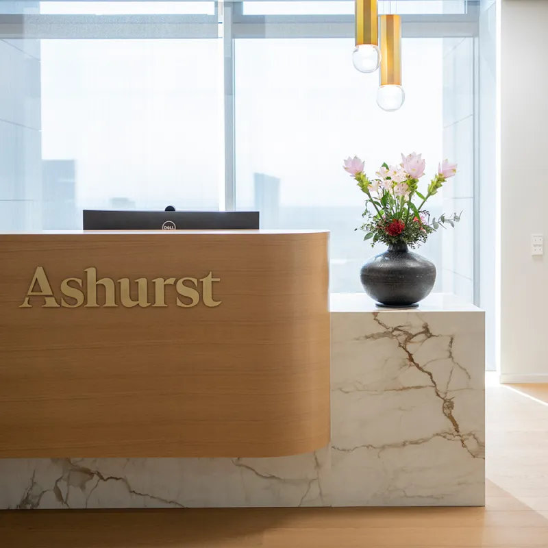 Ashurst: Empfangstresen, verglaste Büros und urbane Skyline im Hintergrund