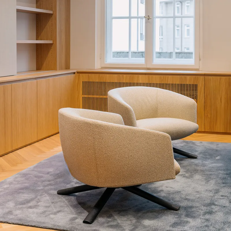 Eleganter Konferenzraum mit hellen bequemen Loungesesseln und Regal im Hintergrund