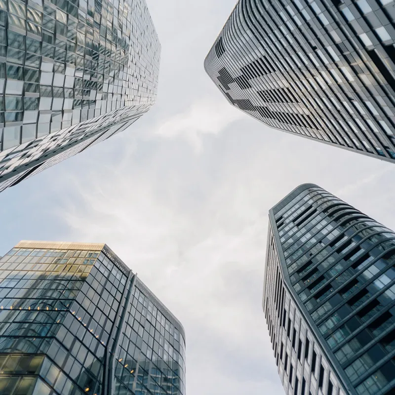 Wirtschaftskanzlei – Bürointerieur: Aussenaufnahme zwischen 4 modernen Büro Tower in den Himmel.