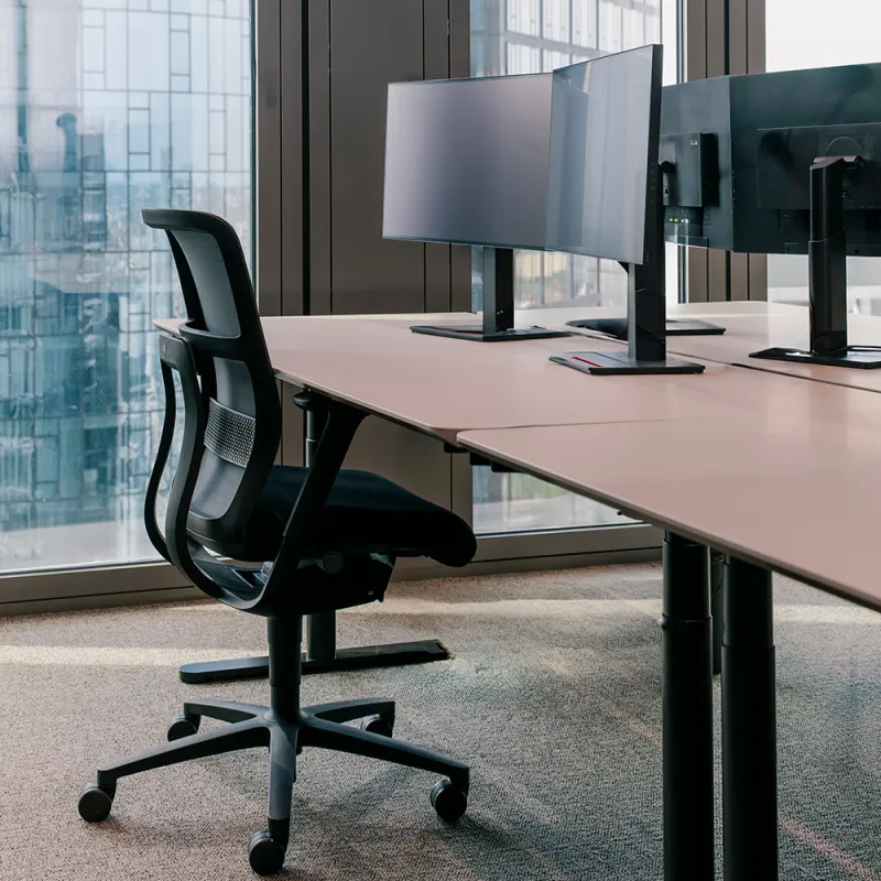 Wirtschaftskanzlei: Moderner Arbeitsplatz mit Schreitisch, Monitor und Bürostuhl.