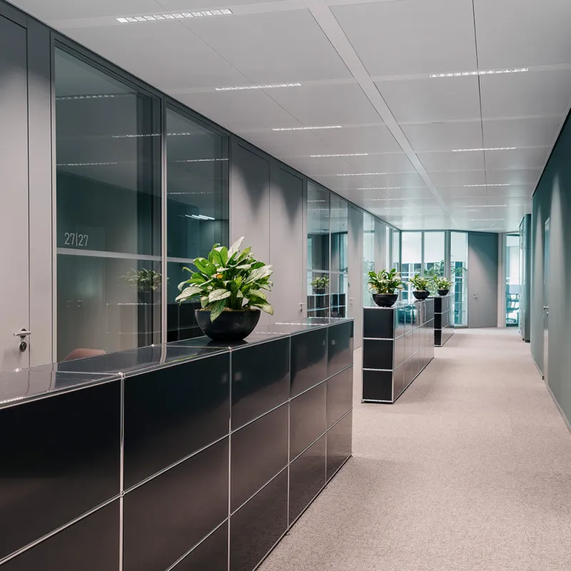 Wirtschaftskanzlei: Blick entlang eines Flurs. Seitlich moderne Möbel als Staufläche.