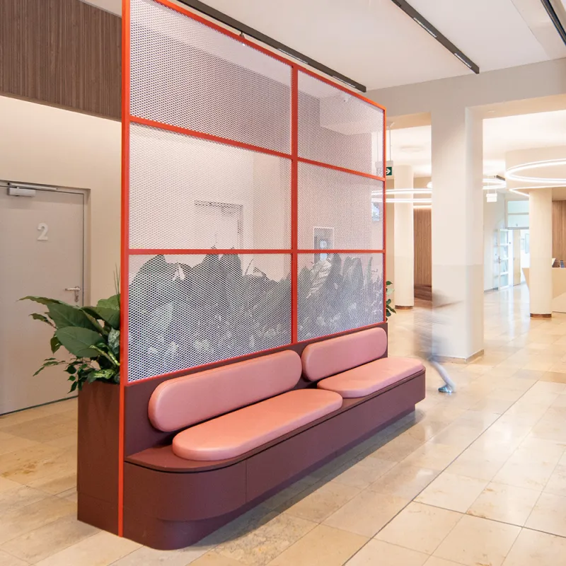 Bürgerhospital Frankfurt: Empfangsbereich mit roter moderner Sitzbank und Raumtrenner.