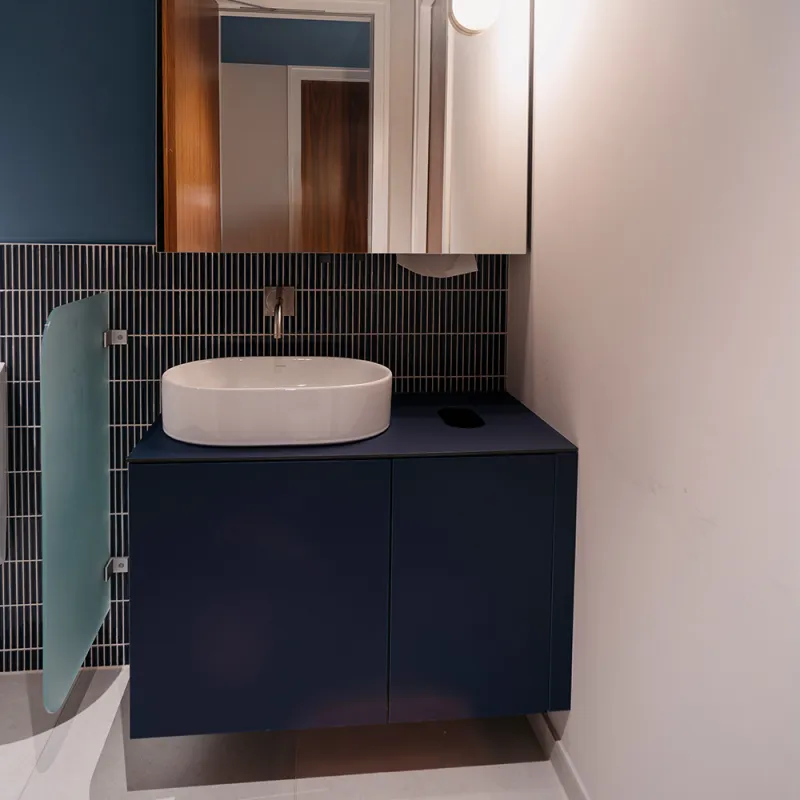 Linklaters Berlin: Waschtisch mit Spiegel und dunkelblauer Kommode