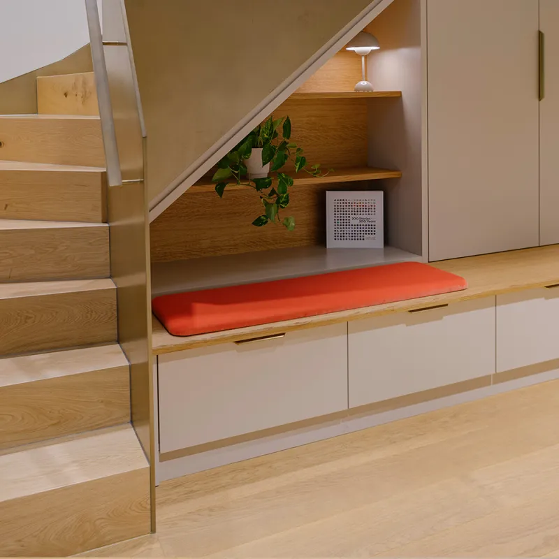 Ashurst München: moderne Holztreppe die in den 1. Stock führt und ein langes Sitzmöbel 