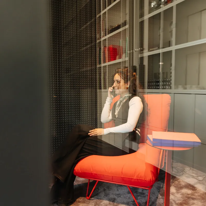 CSMM Berlin: Lounge Möbel in rot mit Bücherregal im Hintergrund